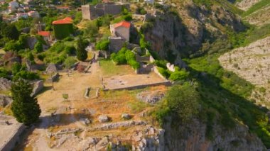 This aerial stock video captures the stunning ruins of the Old Bar or Stari Bar, a historical landmark in Montenegro. The drone footage showcases a birds eye view of a stone fortress and an aqueduct
