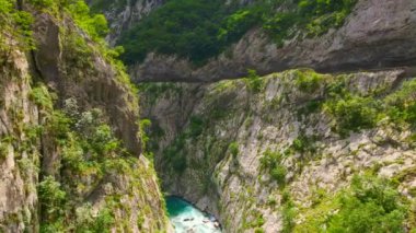 Aerial video of the stunning Moracha River canyon in Montenegro. Soar above the magnificent natural scenery, capturing stunning aerial views of the towering cliffs, crystal-clear river, and lush