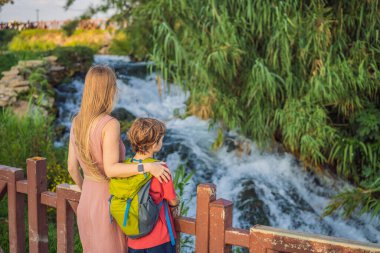 Anne ve oğul turistler Antalya 'daki Duden şelalesinin arka planında. Türkiye 'nin ünlü yerleri. Aşağı Duden Şelaleleri 40 metreden Akdeniz 'e düşen kayalık bir uçurumdan inanılmaz bir şekilde düşüyor.