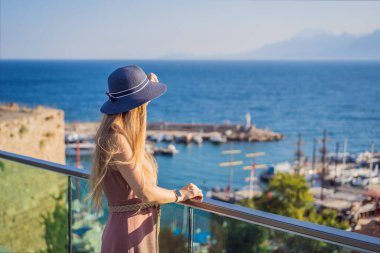 Antalya 'nın Kaleici kasabasındaki kadın turist. Hindi. Antalya Eski Kent limanı, Taurus dağları ve Akdeniz 'in panoramik manzarası, Türkiye.