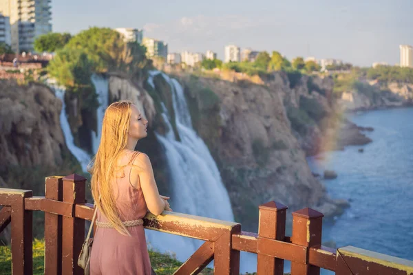 stock image Beautiful woman with long hair on the background of Duden waterfall in Antalya. Famous places of Turkey. Lower Duden Falls drop off a rocky cliff falling from about 40 m into the Mediterranean Sea in