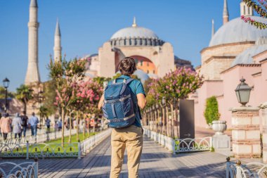 Erkek, Ayasofya Katedrali 'nin, ünlü İslami Tarihi Cami' nin, İstanbul 'a Seyahatin tadını çıkarıyor. Güneşli gün mimarisi ve Eminonu 'daki Ayasofya Müzesi, İstanbul, Türkiye. Türkiye.