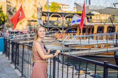 Antalya 'nın Kaleici kasabasındaki kadın turist. Hindi. Antalya Eski Kent limanı, Taurus dağları ve Akdeniz 'in panoramik manzarası, Türkiye.