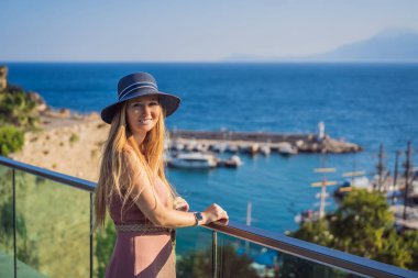 Antalya 'nın Kaleici kasabasındaki kadın turist. Hindi. Antalya Eski Kent limanı, Taurus dağları ve Akdeniz 'in panoramik manzarası, Türkiye.