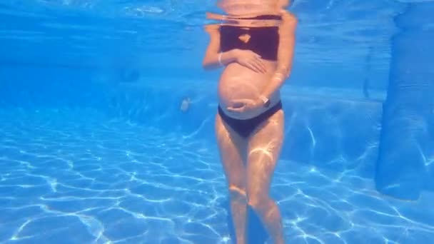Yavaş Çekim Sualtı Videosunda Hamile Bir Kadın Kollarını Karnına Dayamış — Stok video