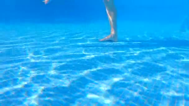 この水中ビデオでは 妊婦がスイミングプールで水の練習をしているのが見られます 彼女の赤ちゃんのバンプで 彼女はの利点を実証し 水の中で簡単に移動します — ストック動画