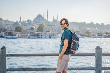Pembe elbiseli genç gezgin İstanbul 'da İstanbul Boğazı manzarası ve bir sürü martı seyrediyor..