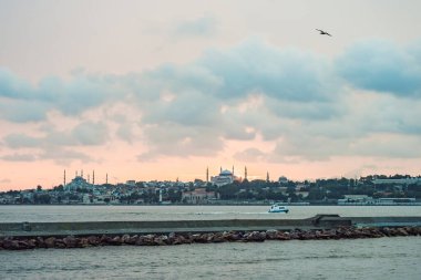 Günbatımında İstanbul, Türkiye. Turist teknesi yazın Golden Horn 'dan denize açılır. İstanbul 'un eski camili güzel güneşli manzarası. İstanbul ve Türkiye 'de seyahat, turizm ve tatil kavramı