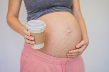 Hamile bir kadın elinde bir fincan kahve tutuyor. Kafein güvenliği, hamilelik süresince kahve hakkındaki efsaneler..