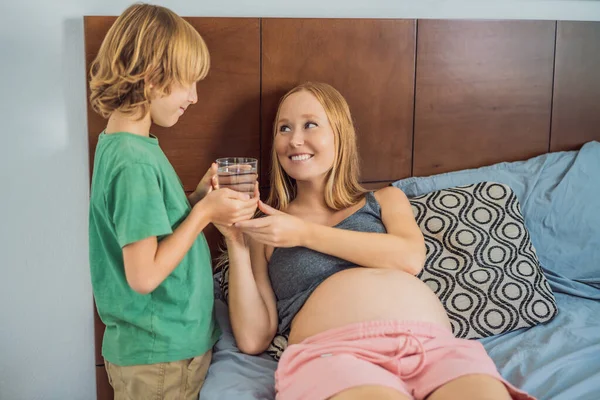Figlio Portato Sua Madre Incinta Bicchiere Acqua — Foto Stock