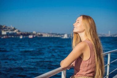 İstanbul 'da İstanbul Boğazı' ndan geçen feribottan denizin keyfini çıkaran mutlu kadın. İstanbul 'a yaz gezisi.