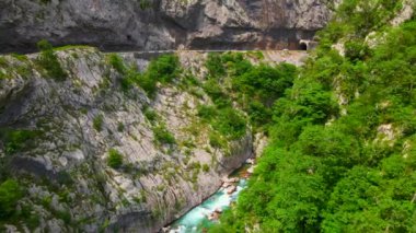 Aerial video of the stunning Moracha River canyon in Montenegro. Soar above the magnificent natural scenery, capturing stunning aerial views of the towering cliffs, crystal-clear river, and lush