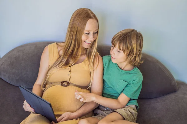 Těhotné Matky Syna Podívejte Tabulku Čtení Knihy Sledování Kresleného Filmu — Stock fotografie