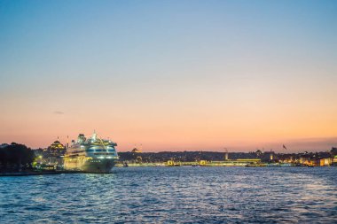 Günbatımında İstanbul, Türkiye. Turist teknesi yazın Golden Horn 'dan denize açılır. İstanbul 'un eski camili güzel güneşli manzarası. İstanbul ve Türkiye 'de seyahat, turizm ve tatil kavramı