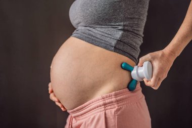 Hamile bir kadın için masaj aleti ile kendine masaj..