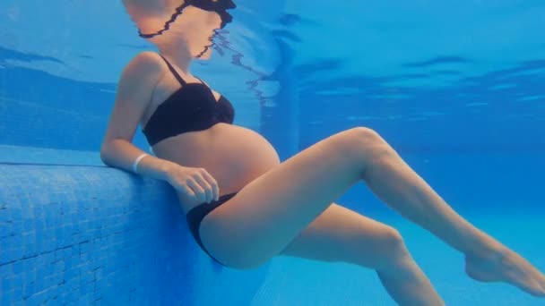 在这个慢动作的水下视频中 一个孕妇在游泳池里进行水上运动 随着婴儿的碰撞 她在水里轻松自在地移动着 这证明了 — 图库视频影像
