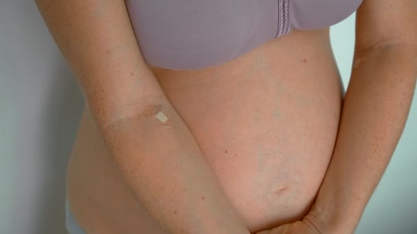 ビデオは 血液検査の目に見える兆候を持つ妊婦の腕を示しています 医師のラベルや包帯は彼女の腕の上に見ることができ 最近の血液検査を示しています カメラは細部に焦点を当てキャプチャします — ストック動画