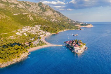 Havacılık bilimi. Karadağ 'ın güzel bir yaz gününde Sveti Stefan adasının insansız hava aracından havadan görünüşü. Aziz Stephen 'ın lüks tatil köyünün üstündeki panoramik. Turizm ve eğlence kavramı.