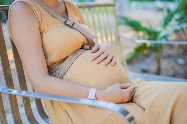 妊娠中の若い女性は公園のベンチで休んでいます — ストック写真