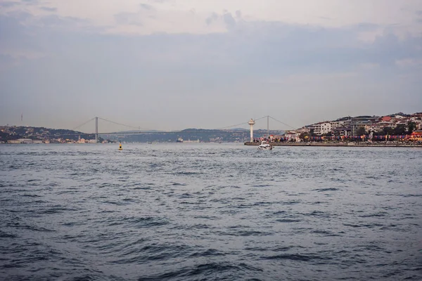 stock image Istanbul at sunset, Turkey. Tourist boat sails on Golden Horn in summer. Beautiful sunny view of Istanbul waterfront with old mosque. Concept of travel, tourism and vacation in Istanbul and Turkey