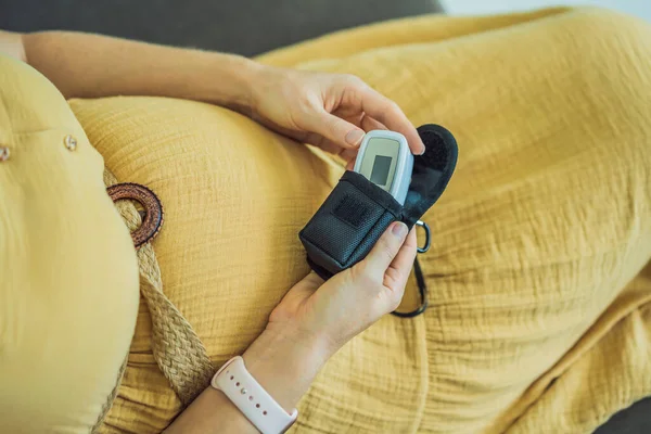 妊娠中の女性の指にパルス酸素濃度計 自宅でコロナウイルス病の妊婦を訪問しながら酸素飽和度を測定医師 クロップド 妊娠中やCovid 19の概念 — ストック写真