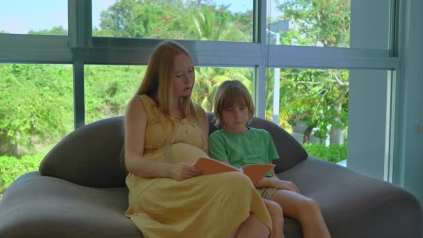 Una Mujer Embarazada Sienta Con Hijo Mayor Acogedor Sofá Rodeado — Vídeo de stock