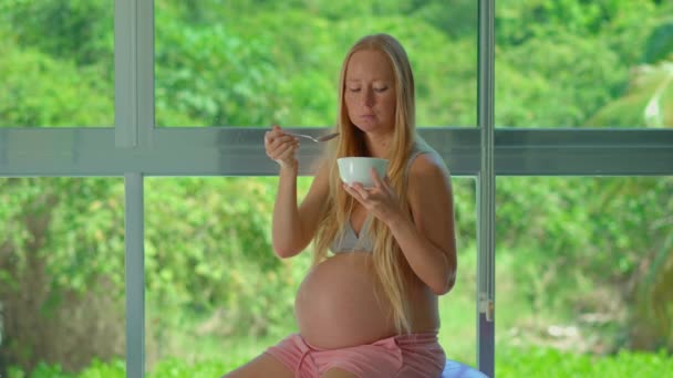 Una Mujer Embarazada Radiante Disfruta Momento Nutritivo Sentada Una Bola — Vídeo de stock