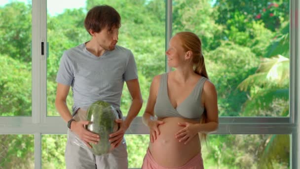 在这个幽默的慢动作视频中 一个孕妇开玩笑地把西瓜绑在她丈夫的肚子上 对怀孕的重量和经历进行了轻松的模拟 — 图库视频影像