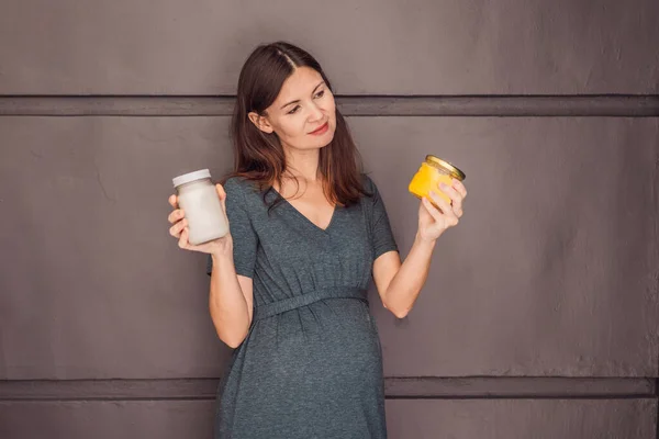 A glowing pregnant woman over 40, savoring nourishing ghee and coconut oil for a healthy and vibrant pregnancy journey.