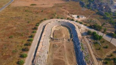 Hava videosu. İnsansız hava aracı, Türkiye 'nin Antalya kentindeki antik Perge kentinin kalıntılarında hipodromun üzerinde uçuyor. Bu görüntüler Antalyas tarihine benzersiz bir bakış açısı sunuyor