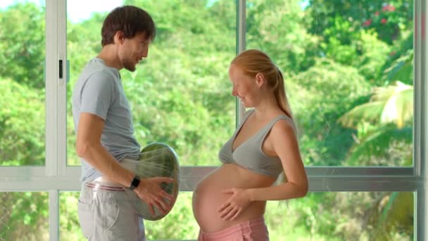このユーモラスなスローモーションビデオでは 妊娠中の女性が自宅の腹にスイカを吹き付け 妊娠の体重と経験を軽くシミュレーションしました 踊ったり — ストック動画