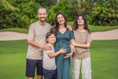 Sevgi dolu bir aile parkta sakin bir şekilde yürüyor. 40 yaşından sonra ışıl ışıl hamile bir kadın, kocası tarafından kucaklanıyor ve yanında yetişkin çocukları da var. Birlikte geçirdikleri değerli anların tadını çıkarıyorlar.