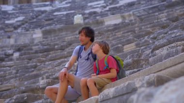 Bu anımsatıcı stok videosunda, antik Aspendos şehri turist bir ailenin varlığıyla canlanıyor. Kamera, harabeleri büyüleyici bir perspektiften yakalar.