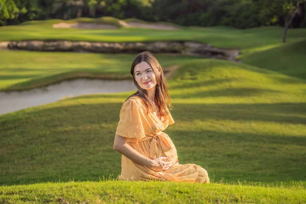 40歳以降の穏やかで輝かしい妊婦は 公園の自然の美しさに囲まれ 輝く笑顔で母性の旅を大切にしています — ストック写真