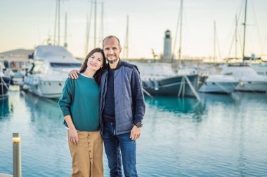 Karadağ 'ın Lustica Körfezi' ndeki mimari ve lüks yatların manzarasının keyfini çıkaran aşık turist çiftler. Karadağ 'da seyahat etmek. Her yere git..