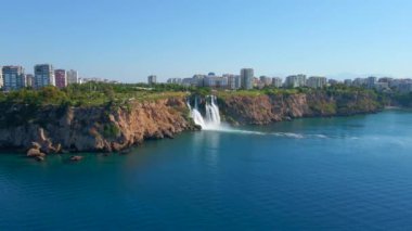 Antalya şehrindeki Lower Duden Şelalesi 'nin yavaş çekim videosu. İHA geriye doğru hareket ediyor. Çevredeki parkları ve binaları gösteriyor.