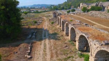 Bu büyüleyici havacılık videosunda, Türkiye 'nin Antalya kentindeki antik Perge kentinin dikkate değer kalıntıları gösteriliyor. Kamera zarif bir şekilde yukarıda süzülüyor, bir panoramik sunuyor.