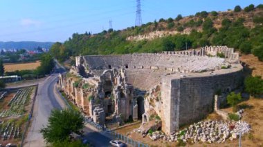 Bu büyüleyici hava videosunda, antik Perge şehrinin kalıntıları, tarihi harabelerin içine yerleştirilmiş çarpıcı bir amfitiyatroyu gözler önüne seriyor. Bu amfi tiyatro, bir vasiyet.