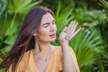 Hamile kadın 40 'ından sonra aroma kolyesi kullandığını gösteriyor. Hamilelik yolculuğunda stil ve aromaterapiyi birleştiriyor..