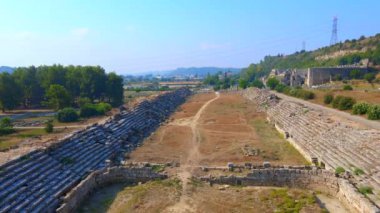 Hava videosu. İnsansız hava aracı, Türkiye 'nin Antalya kentindeki antik Perge kentinin kalıntılarında hipodromun üzerinde uçuyor. Hipodrom, geçmişin canlı yaşamının bir göstergesidir.