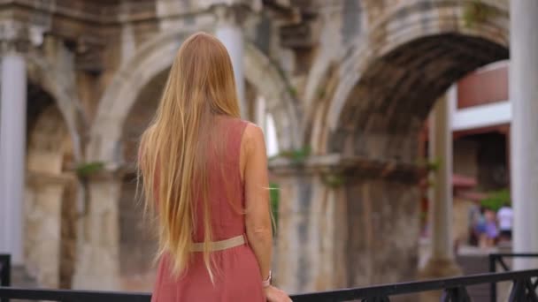 在这个迷人的视频中 一位年轻的女游客正在参观安塔利亚 哈德里安门的著名旅游景点 她站在富丽堂皇的拱廊前 装饰着复杂的拱廊 — 图库视频影像