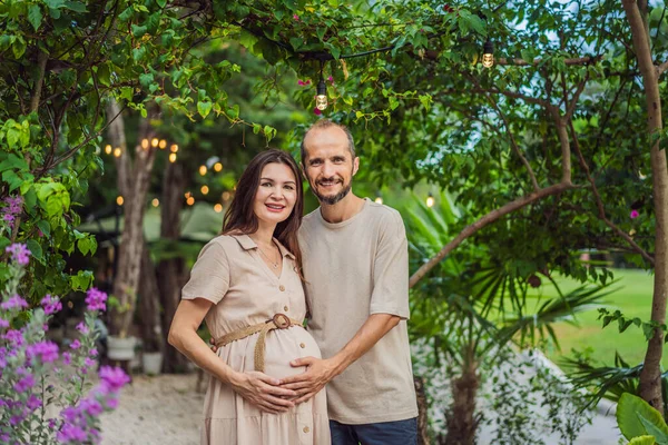A blissful scene in the park as a radiant pregnant woman after 40 and her loving husband after 40, cherish the joy of parenthood together, surrounded by natures serenity.