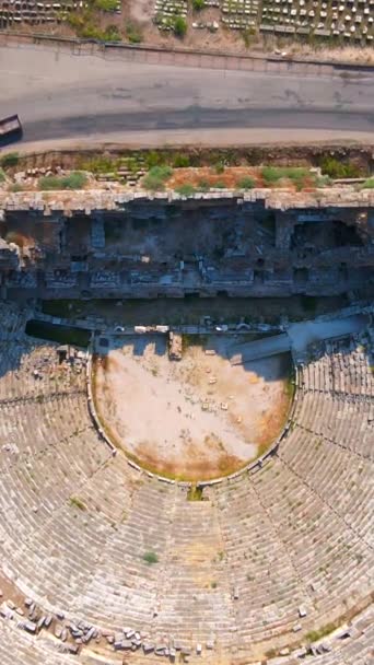 バーティカルビデオ ストーリーフォーマット この魅惑的な空中ビデオでは 古代都市ペルゲの残骸が歴史的な遺跡に囲まれた素晴らしい円形劇場を展示しています — ストック動画