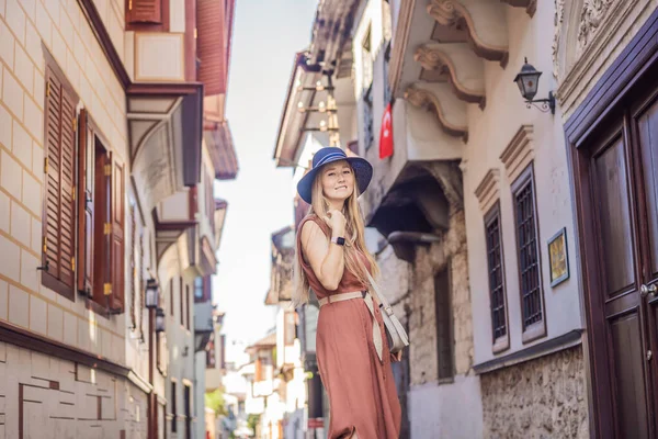 Antalya 'nın arka planındaki mutlu kadın turist. Kadın turist ilginç yerler ve popüler yerler keşfediyor ve Türkiye 'nin Antalya kentindeki eski Kalechi kentinde yürüyor. Türkiye.