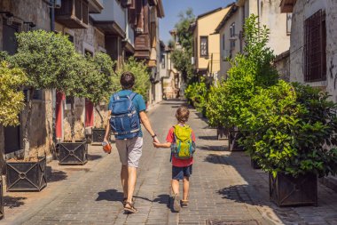 Antalya 'nın arka planında mutlu baba ve oğul turistler. Çocuk konseptiyle seyahat etmek. Erkek turist ilginç yerler ve popüler yerler keşfeder ve eski şehirde yürür.