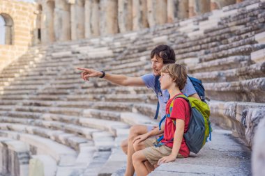 Father and son tourists explores Aspendos Ancient City. Traveling with kids concept. Aspendos acropolis city ruins, cisterns, aqueducts and old temple. Aspendos Antalya Turkey. turkiye. clipart