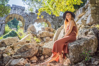 Kadın turist, Antik Termessos Şehrinin Çarpıcı Antik Tiyatrosunu keşfediyor. Hindi, her yere git.