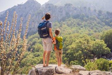 Baba ve oğul turistler Büyüleyici Antik Termessos Tiyatrosu 'nu keşfediyorlar. Çocuk konseptiyle seyahat etmek. Hindi, her yere git..