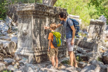 Baba ve oğul turistler Büyüleyici Antik Termessos Tiyatrosu 'nu keşfediyorlar. Çocuk konseptiyle seyahat etmek. Hindi, her yere git..