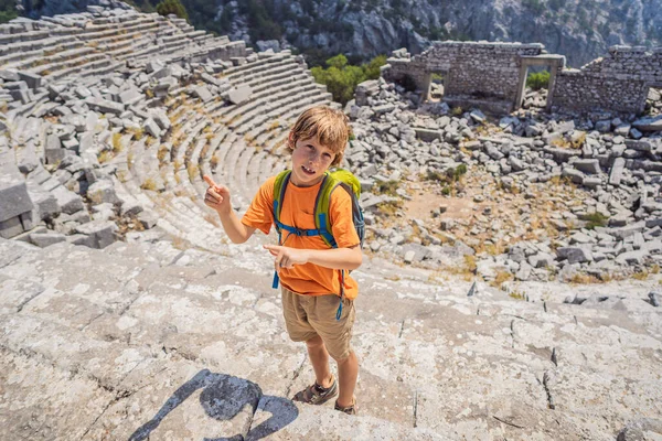 boy explores Stunning Ancient Theater of Termessos Ancient City. Traveling with kids concept. turkiye, GO Everywhere.